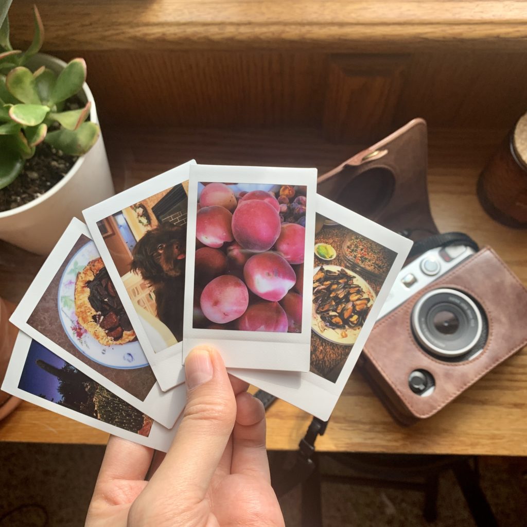 Instax prints next to Evo camera