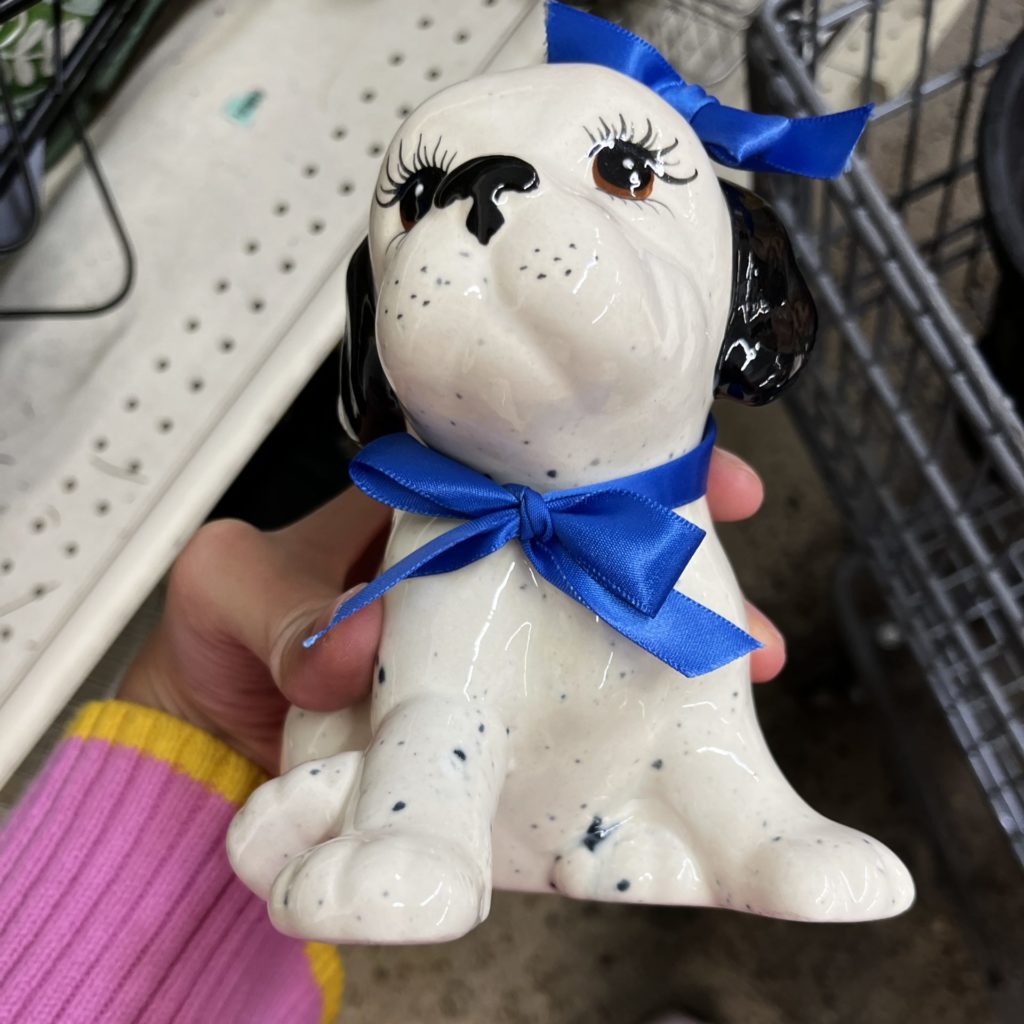 Cute dog figurine with long eyelashes and blue ribbon