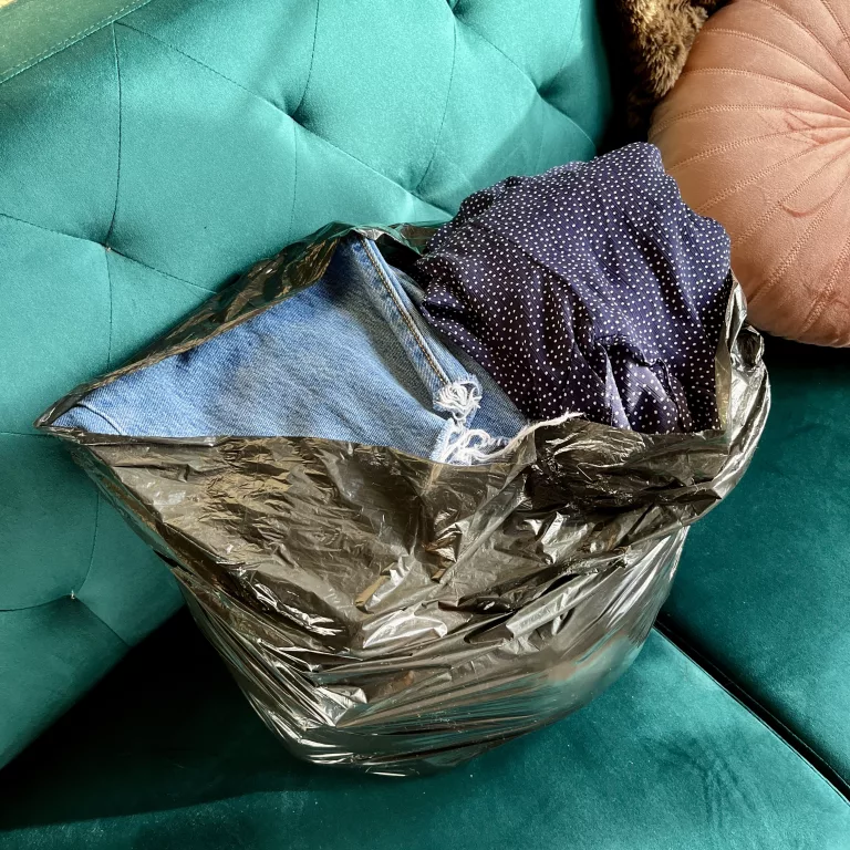 Bag full of clothes on a teal sofa