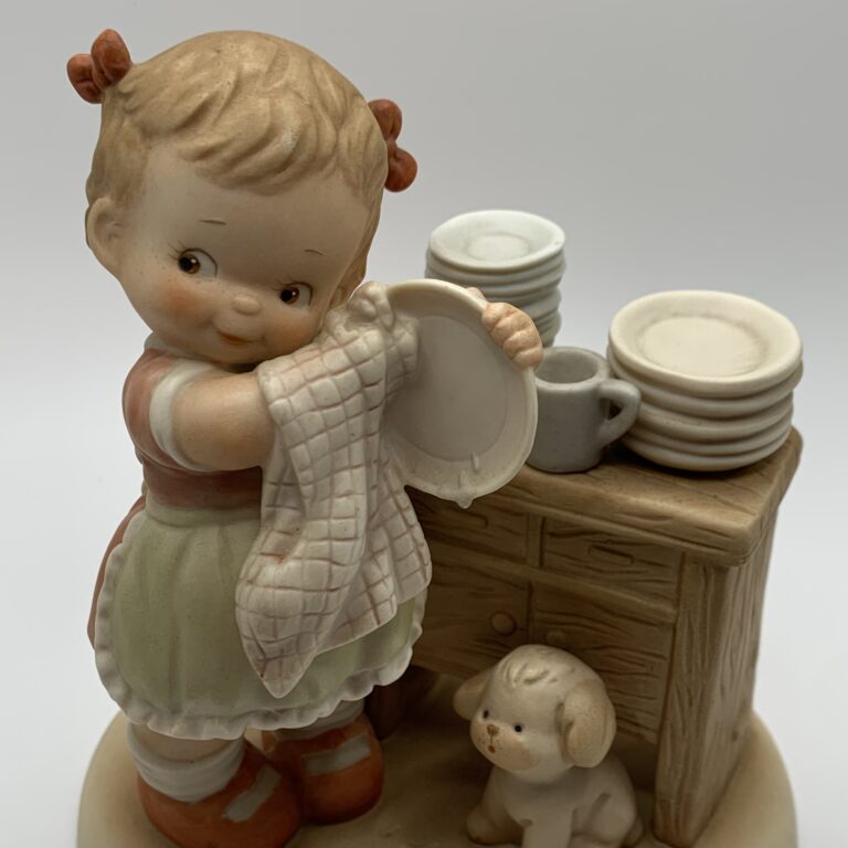 Girl washing dishes with dog at feet